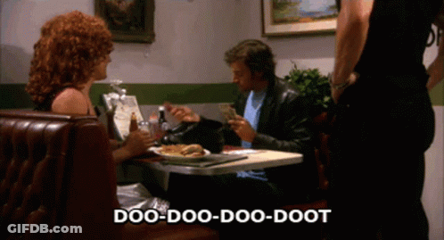 A Man And Woman Sit At A Table In A Diner With The Words Doo-Doo-Doo-Doot Written Above Them GIF