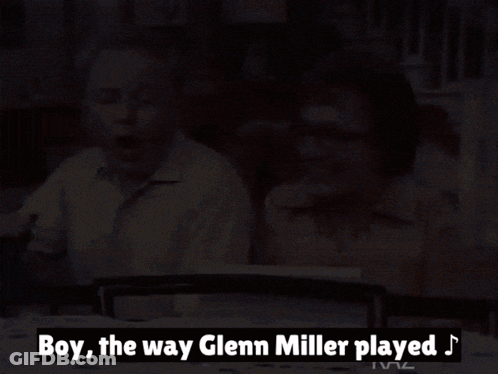 Man And Woman Sitting At Table With Glenn Miller Text GIF