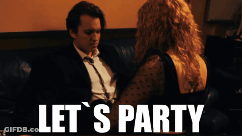 A Man And Woman Sitting On A Couch With The Words Let 'S Party GIF