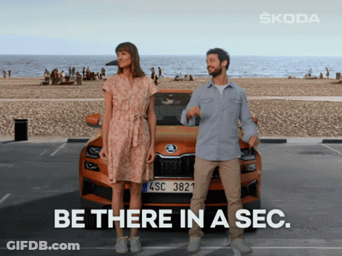 A Man And Woman Standing In Front Of A Skoda Car That Says Be There In A Sec GIF