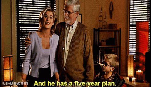 A Man And Woman Standing Next To A Boy With The Words And He Has A Five Year Plan GIF