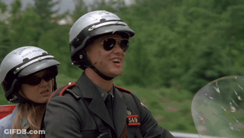 A Man And Woman Wearing State Police Helmets GIF