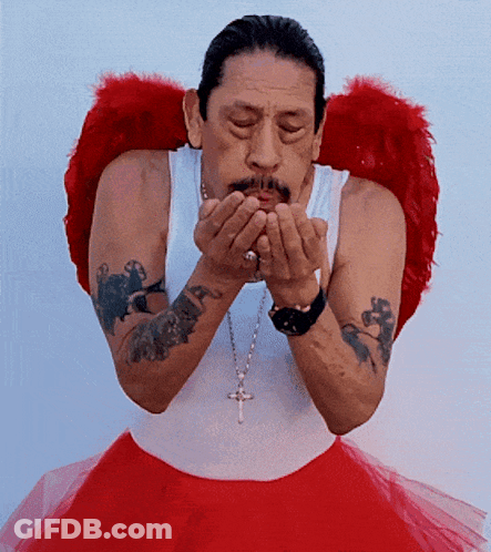 A Man Blowing A Kiss Wearing Red Angel Wings And A Red Tutu GIF