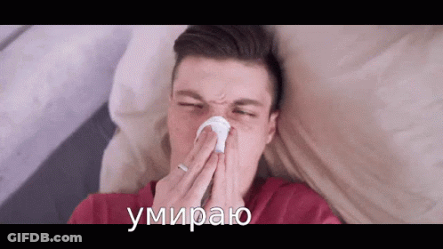 A Man Blowing His Nose With A Napkin And The Words " Умираю " Written On The Bottom Right GIF