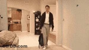 A Man Carrying A Backpack Is Walking Through A Living Room GIF