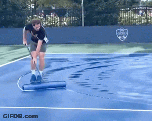 A Man Cleaning A Tennis Court With A Roller GIF