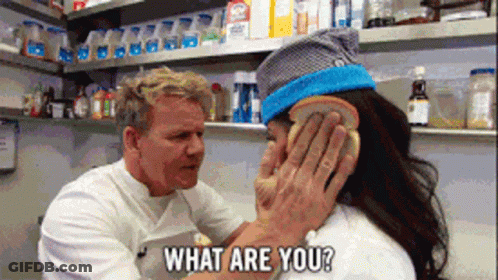A Man Covering A Woman 'S Ear With A Piece Of Bread And The Words What Are You Behind Him GIF