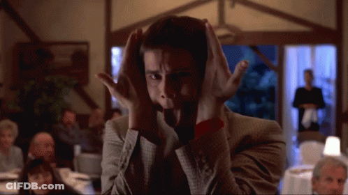 A Man Covering His Ears With His Hands In Front Of A Crowd GIF