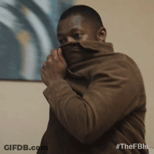A Man Covering His Face With A Brown Jacket With The Hashtag #Thefbis GIF