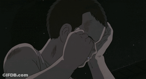 A Man Covering His Face With His Hand In A Dark Room GIF