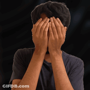 A Man Covering His Face With His Hands In Front Of A Black Background GIF