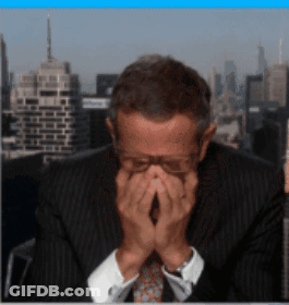 A Man Covering His Face With His Hands In Front Of A City Skyline GIF