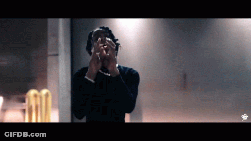 A Man Covering His Face With His Hands In Front Of A Wall GIF