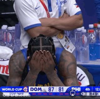 A Man Covering His Face With His Hands While Watching A Basketball Game In The World Cup Group Phase GIF