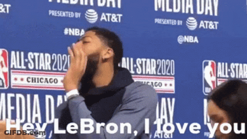 A Man Covering His Mouth While Standing In Front Of A Sign That Says Media Day GIF