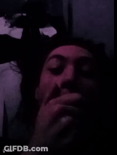 A Man Covering His Mouth With His Hand In A Dark Room With A Nokia Logo On The Bottom Right GIF