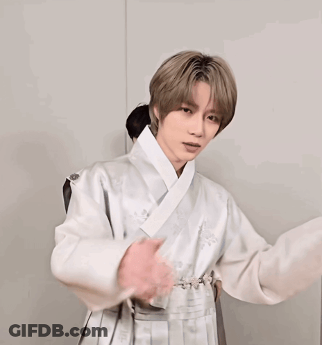 A Man Covering His Mouth With His Hands And Wearing A White Jacket GIF