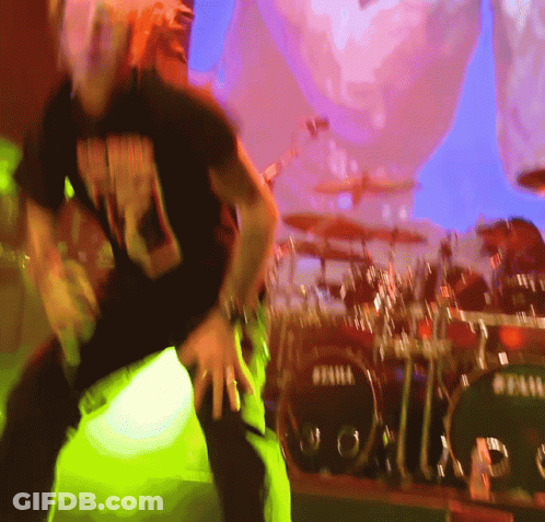A Man Dancing In Front Of A Drum Set That Says Tama GIF