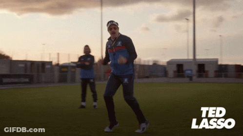 A Man Dancing On A Field With The Name Ted Lasso In The Corner GIF