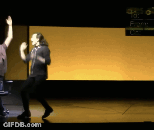 A Man Dancing On A Stage In Front Of A Screen That Says " To : From " GIF