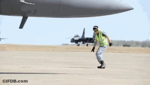A Man Doing A Handstand In Front Of A Plane GIF