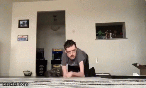 A Man Doing Push Ups In A Living Room With A California License Plate On The Wall GIF