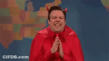 A Man Dressed As A Devil With Horns Is Praying With His Hands Folded . GIF