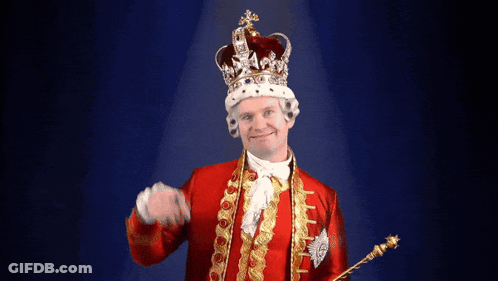 A Man Dressed As A King With A Crown And Scepter GIF