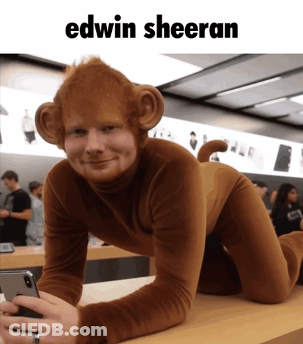 A Man Dressed As A Monkey Is Holding A Cell Phone GIF
