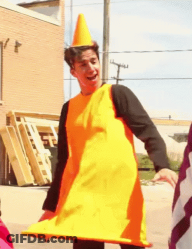 A Man Dressed As A Traffic Cone Is Smiling GIF