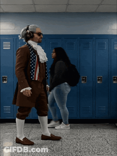 A Man Dressed As Benjamin Franklin Is Walking In A Hallway With Blue Lockers GIF
