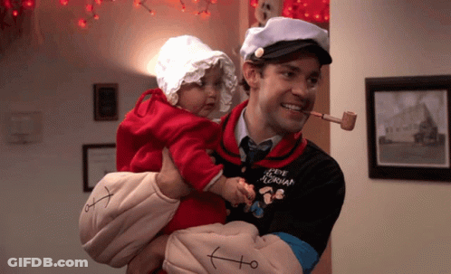 A Man Dressed As Popeye Holds A Baby In His Arms GIF
