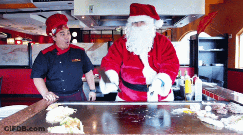 A Man Dressed As Santa Claus Is Cooking Food GIF