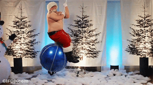 A Man Dressed As Santa Claus Is Riding A Blue Ball GIF