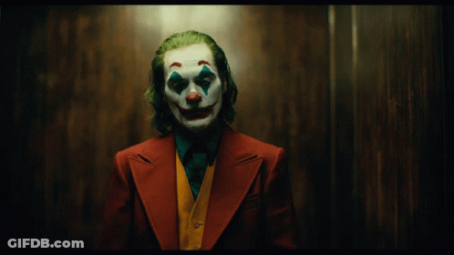 A Man Dressed As The Joker With A Clown Face And Green Hair GIF