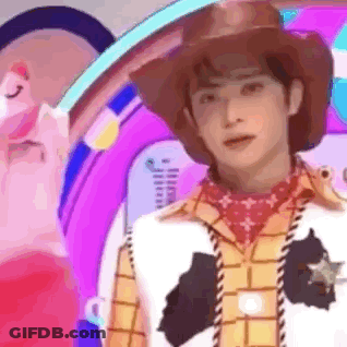 A Man Dressed As Woody From Toy Story Is Standing In Front Of A Purple Background . GIF