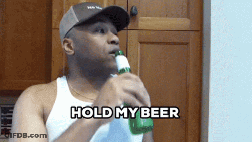 A Man Drinking A Bottle Of Beer With The Words Hold My Beer Behind Him GIF