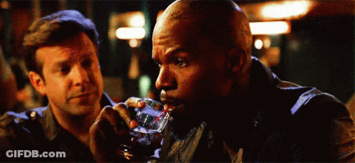 A Man Drinking A Glass Of Whiskey Next To Another Man GIF