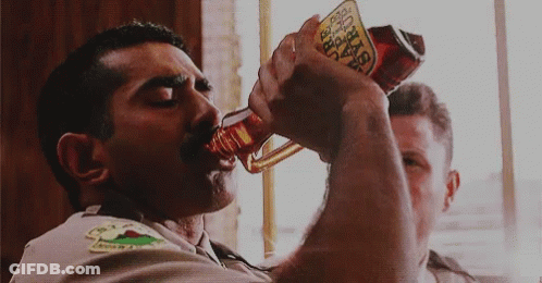 A Man Drinking From A Bottle That Says Tabasco On It GIF