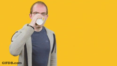 A Man Drinking From A Cup In Front Of A Yellow Background That Says " Stay Focused " GIF