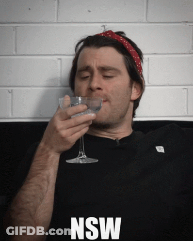 A Man Drinking From A Glass With The Word Nsw On The Bottom Right GIF