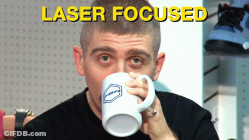 A Man Drinking From A Mug That Says Laser Focused On The Bottom GIF