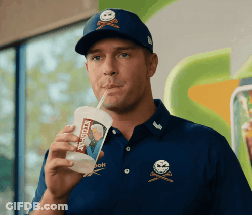 A Man Drinking Through A Straw From A Cup That Says " Snickers " On It GIF