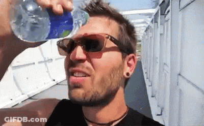 A Man Drinking Water From A Bottle While Wearing Sunglasses . GIF