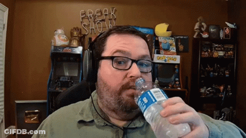 A Man Drinking Water From A Bottle With A Break Show Sign In The Background GIF