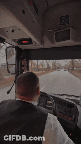 A Man Driving A Bus With The Time 1630 On The Top Of The Dashboard GIF