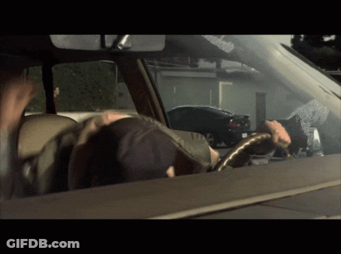 A Man Driving A Car With A Sticker On The Windshield That Says ' A ' On It GIF