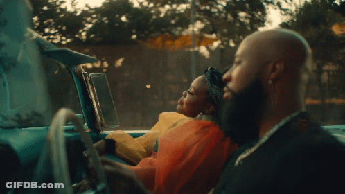 A Man Driving A Car With A Woman Sitting In The Back Seat GIF