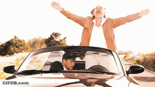 A Man Driving A Car With His Arms Outstretched GIF