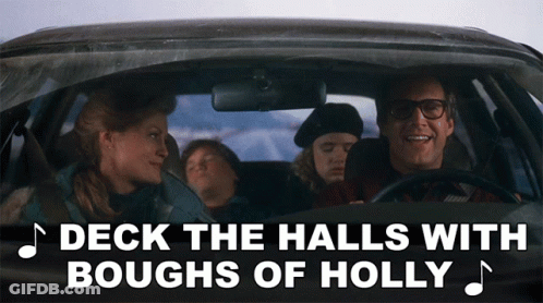 A Man Driving A Car With The Words Deck The Halls With Boughs Of Holly GIF